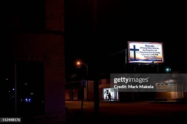 Pedestrian walks below a billboard advertising sunday school radio across the street from the Cumberland United Methodist Church, where Democratic...