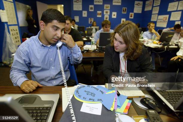 Caittlin Klevorick and Faiz Shakir, both staffers, work in the "war room" at the headquarters of the Democratic Rapid Response team on August 30,...