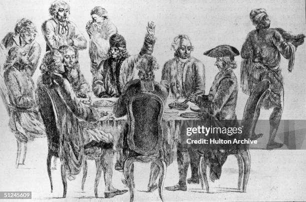 Circa 1750, French philosopher and writer Francois Marie Arouet, better known as Voltaire , at a dinner attended by fellow intellectuals d'Alembert ,...