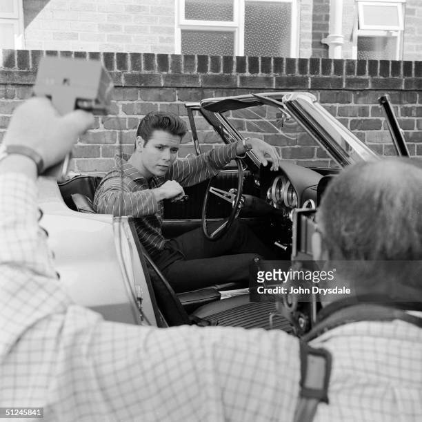 27th August 1963, British pop star Cliff Richard poses for the cameras at the wheel of his Chevrolet Corvette.