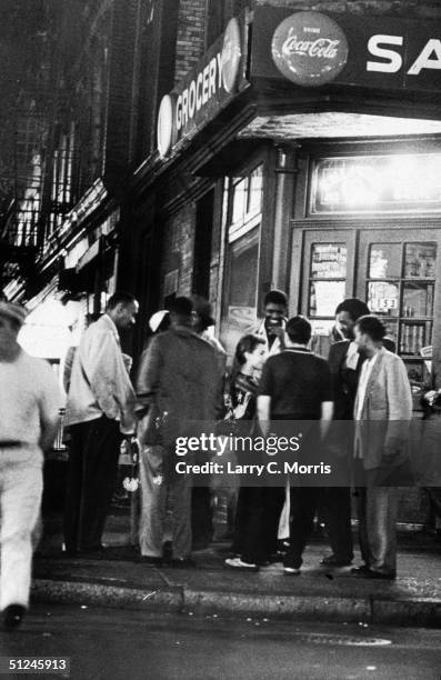 27th September 1959, A group of people stands across the street from the Greenwich Hotel, near Thompson and Bleecker Streets in the Greenwich Village...