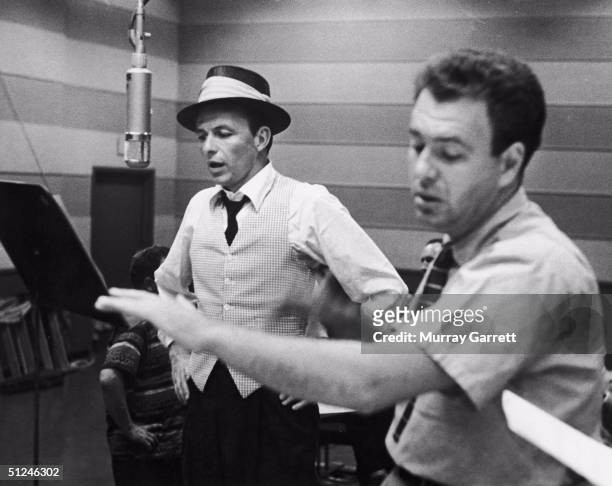 Circa 1953, American singer and actor Frank Sinatra with his conductor and arranger Nelson Riddle during a recording session at Capitol Records.