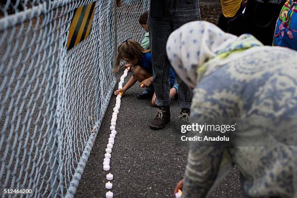 Protestors place candles outside the gates of a refugee detention centre during a candlelight vigil as protestors stand in solidarity with refugees...