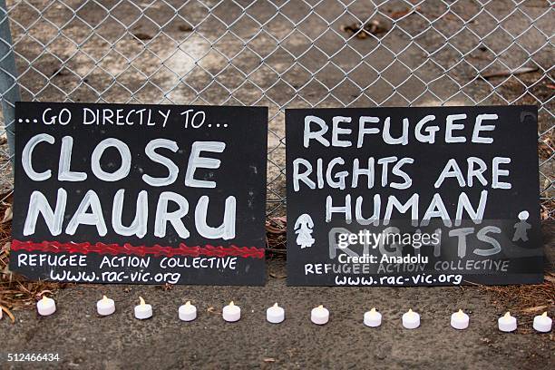 Two banners and candles at the gates of a refugee detention centre during a candlelight vigil as protestors stand in solidarity with refugees in...
