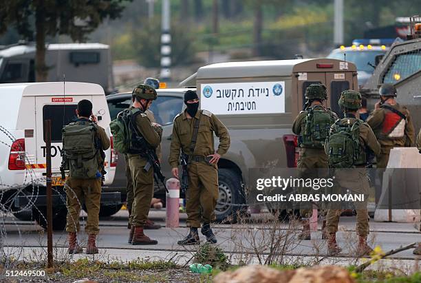 Israeli security forces monitor the area where a Palestinian man tried to stab Israeli soldiers before being shot dead at a checkpoint near Ramallah,...