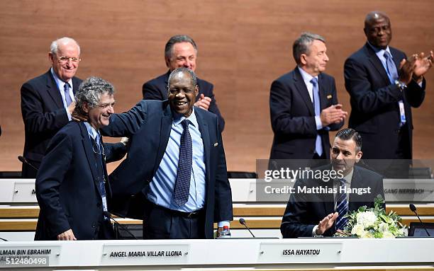 Acting President Issa Hayatou acknowledges applause from fellow delegates with FIFA Vice President Angel Maria Villar Llona and FIFA Acting Secretary...