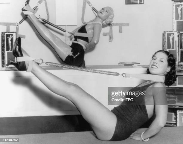Woman uses a piece of exercise equipment made from a spring, 1935.