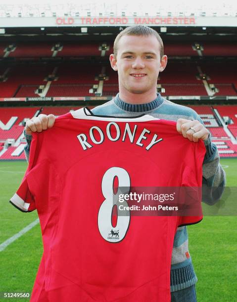 Wayne Rooney poses for photographs with a Manchester United shirt after signing for Manchester United on August 31, 2004 at Old Trafford in...