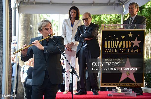 Italian composer Ennio Morricone listens as flutist Andrea Griminelli performs at Morricone's Hollywood Walk of Fame Star ceremony on February 26,...