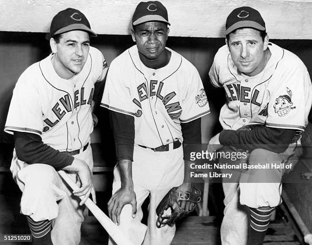 Lou Boudreau, Larry Doby and Manager Hank Greenberg of the Cleveland Indians pose in the dugout during a season game. Lou Boudreau played for the...