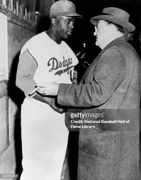 Jackie Robinson talks with Owner Walter O'Malley of the Brooklyn Dodgers. Jackie Robinson played for the Brooklyn Dodgers from 1947-1956.