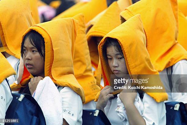 Wearing flame-proof hoods, elementary school children evacuate during a joint disaster drill incorporating the Ground Self-Defense Force, Maritime...