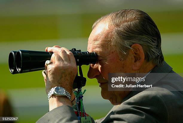 On the day a number of jockies and trainers were arrested for alleged racing irregularities a racegoer watches the horses head to the start of The...