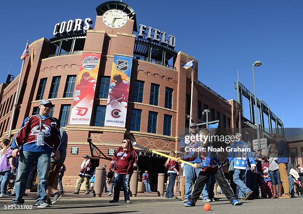 Young fan takes a swing at a hockey ball at spectator plaza during practice day the 2016 Coors Light Stadium Series between the Detroit Red Wings and...