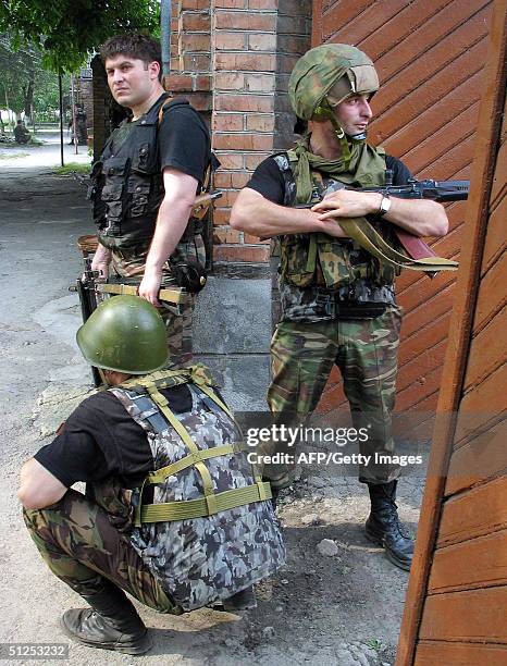 Russian special forces soldiers wait in position near the school, where a group of gunmen, wearing belts laden with explosives, are holding hostage...