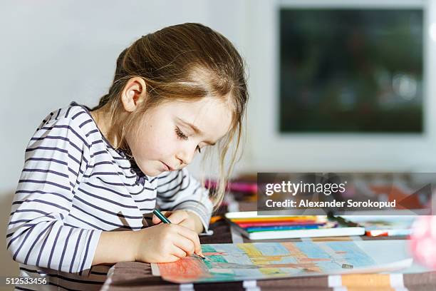 cute little girl painting by colorful pencil at home - お絵かき ストックフォトと画像