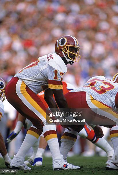 Quarterback Doug Williams of the Washington Redskins calls a play at the line of scrimmage during Super Bowl XXII against the Denver Broncos at Jack...
