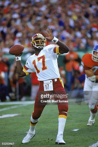 Quarterback Doug Williams of the Washington Redskins looks to pass during Super Bowl XXII against the Denver Broncos at Jack Murphy Stadium on...