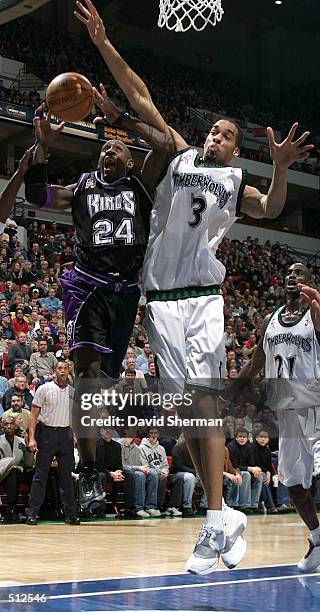 Bobby Jackson of the Sacramento Kings is fouled on his way to the basket by Loren Woods of the Minnesota Timberwolves at Target Center in...