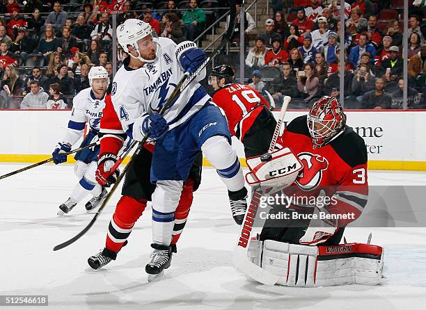 Cory Schneider of the New Jersey Devils makes the first period blocker save as Ryan Callahan of the Tampa Bay Lightning looks for the rebound at the...