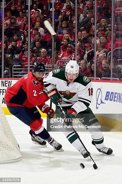 Ryan Carter of the Minnesota Wild controls the puck behind the net against Matt Niskanen of the Washington Capitals in the second period during their...