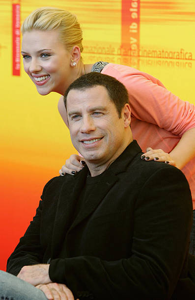 Actress Scarlett Johansson smiles as she poses with actor John Travolta during a photo call at Venice Lido 2 September 2004. Johansson and Travolta...