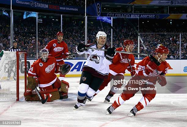 Mike Ricci of the Colorado Avalanche Alumni hooks Darren McCarty of the Detroit Red Wings Alumni during the 2016 Coors Light Stadium Series Alumni...