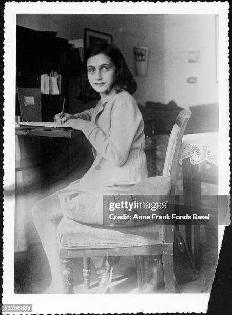 Anne Frank writing at her desk in her house at Merwedeplein, Amsterdam, circa 1941.