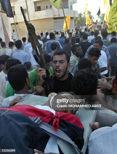 Palestinian mourners carry the body of Mohammad Barakeh during his funeral in the central Gaza Strip town of Deir al-Balah, 02 September 2004. Three...