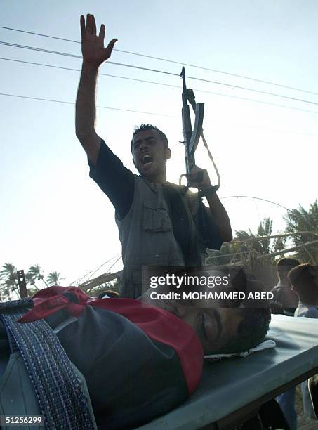 Palestinian militant chants slogans as the body of Mohammad Barakeh is carried during his funeral in the central Gaza Strip town of Deir al-Balah, 02...