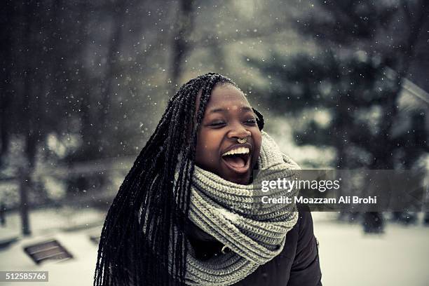 young woman laughing while it's snowing outside - black snow stock pictures, royalty-free photos & images