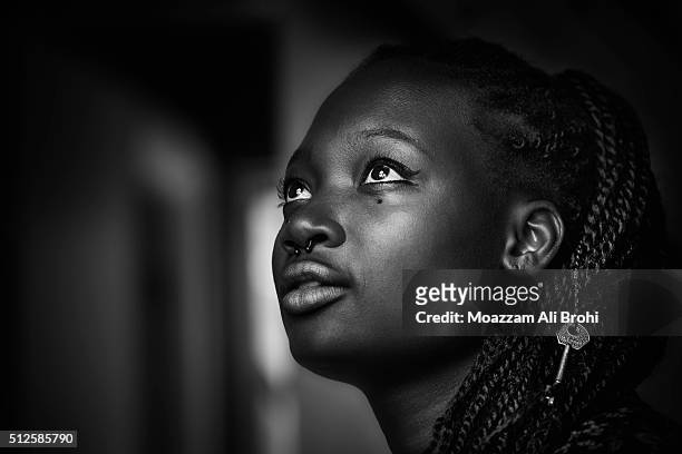 black & white portrait of young black woman looking up - bianco e nero foto e immagini stock