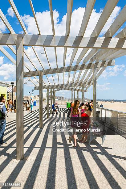 People under the canopy of the 109th street Rockaway Beach station and boardwalk. Queens New York, August 24, 2014