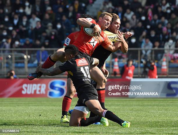 Riaan Viljoen of the Sunwolves is tackled by Elton Jantjies and Andries Ferreira of the Lions during the round one Super Rugby match between the...