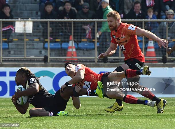 Howard Mnisi of the Lions is tackled by Akihito Yamada of the Sunwolves as teammate Edward Quirk looks on, during the round one Super Rugby match...