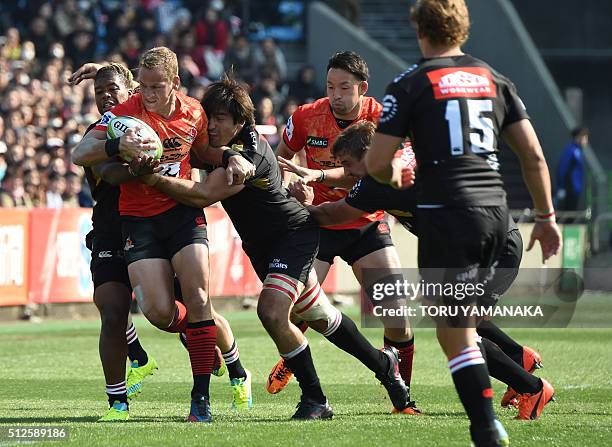 Riaan Viljoen of the Sunwolves is tackled by Howard Mnisi and Warwick Tecklenburg of the Lions during the round one Super Rugby match between the...