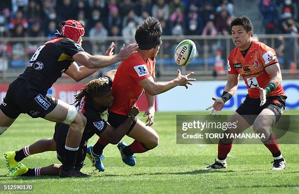 Shota Horie of the Sunwolves passes the ball to teammate Harumichi Takekawa as he is tackled by Howard Mnisi and Jaco Kriel of the Lions during the...