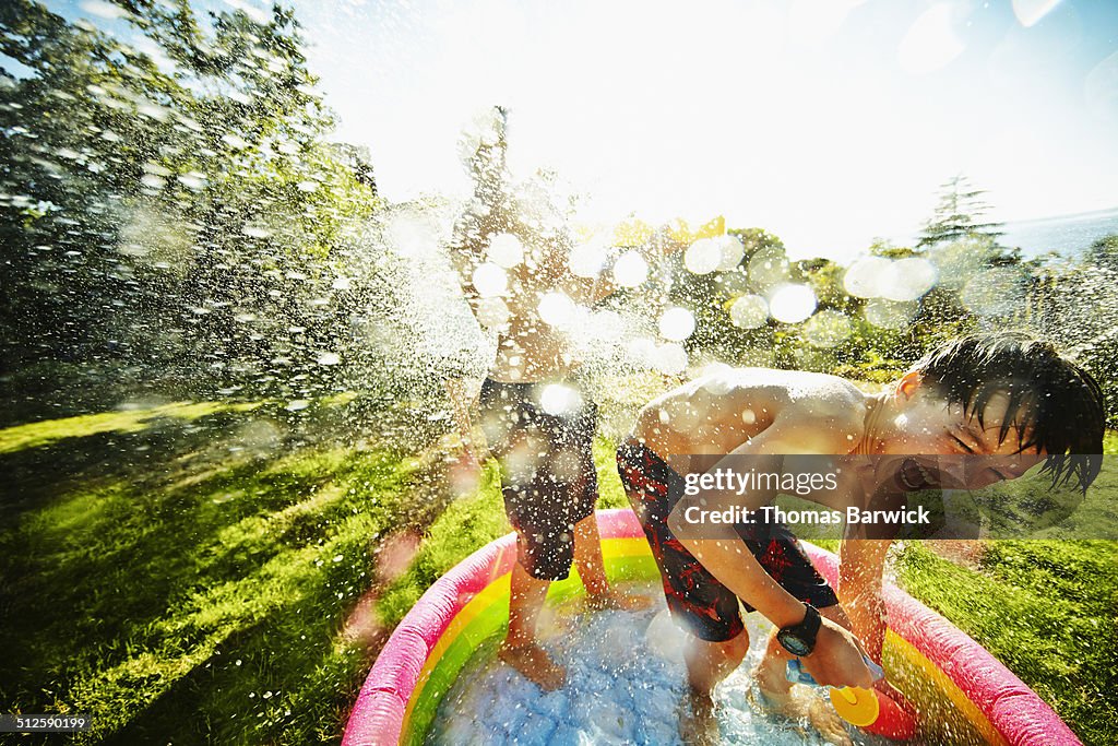 Laughing boy having a water fight with friends