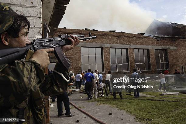 Soldier covers the roof as volunteers survey the area after special forces stormed a school seized by Chechen separatists on September 3, 2004 in the...