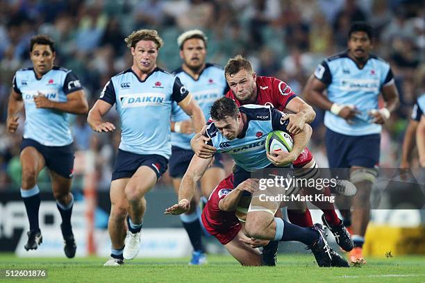 Jed Holloway of the Waratahs is tackled during the round one Super Rugby match between the Waratahs and the Reds at Allianz Stadium on February 27,...