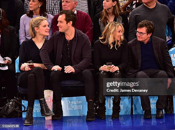 Phillipa Coan, Jude Law, Tracy Pollan and Michael J. Fox attend the Orlando Magic vs New York Knicks game at Madison Square Garden on February 26,...