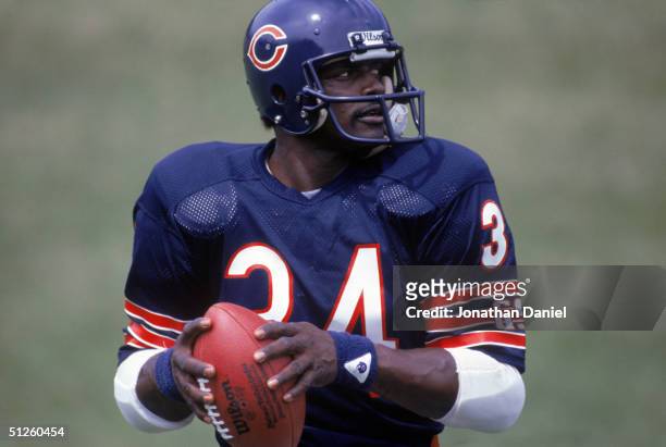 Running back Walter Payton of the Chicago Bears looks on to pass during training camp in 1985.