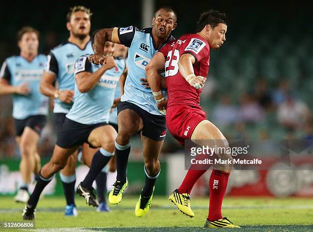 Kurtley Beale of the Waratahs collides with Ayumu Goromaru of the Reds after a kick ahead during the round one Super Rugby match between the Waratahs...