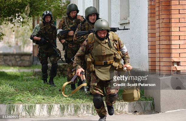 Russian troops run past sniper fire near a school September 3, 2004 in Beslan, Russia. More than 200 people were reportedly killed and at least 700...