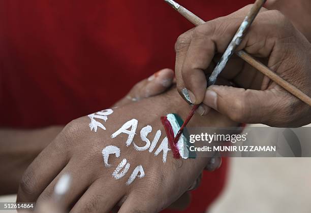 Bangladesh cricket spectator paints the national flag of India onto a fello spectator's hand ahead of the match between India and Pakistan at the...