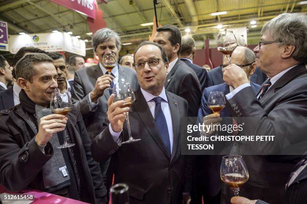 French President Francois Hollande drinks wine during his visit to the 50th International Agriculture Fair of Paris at the Porte de Versailles...
