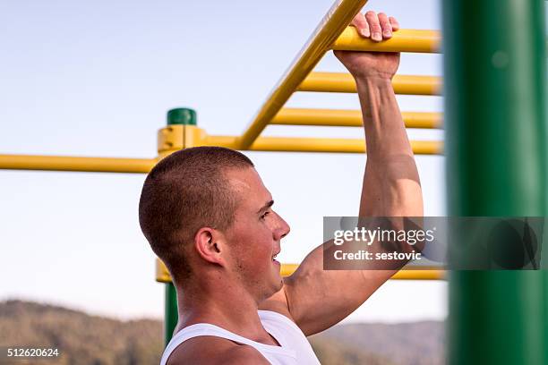 hard one arm pull-ups - hand on chin stockfoto's en -beelden