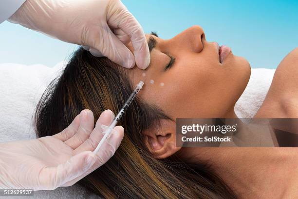 gemischtes frau empfangende botox-spritze - botox injections stock-fotos und bilder