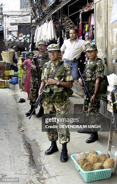 Nepalese soldiers and a local shopkeeper look on as unseen representatives from Nepal's Hindu, Buddhist, Muslim and Christian communities participate...