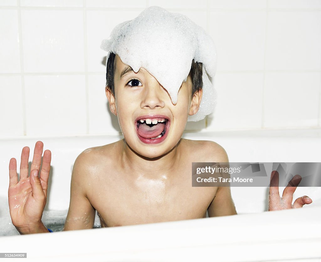 Boy with bath bubbles in bath